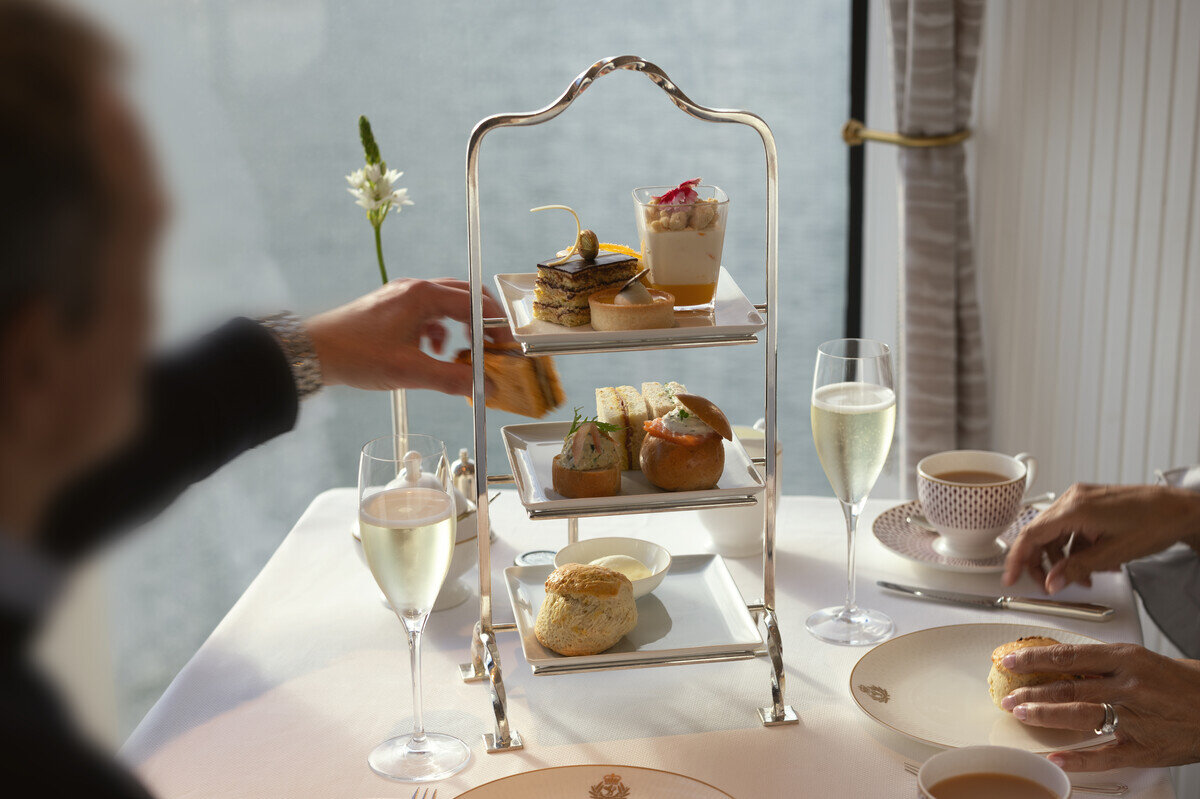 Afternoon tea served on a tiered stand with champagne in a Cunard Grills suite
