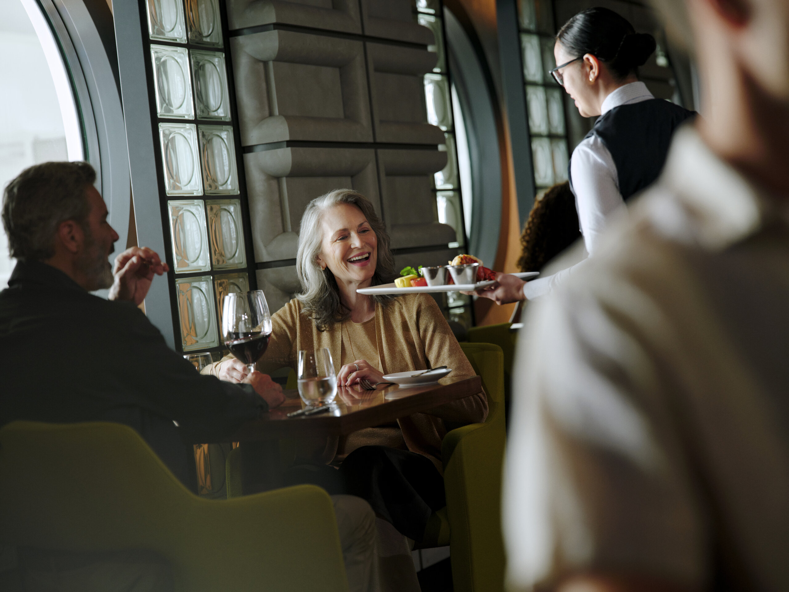 Guests being served dinner at Cagney's Steakhouse on Norwegian Aqua